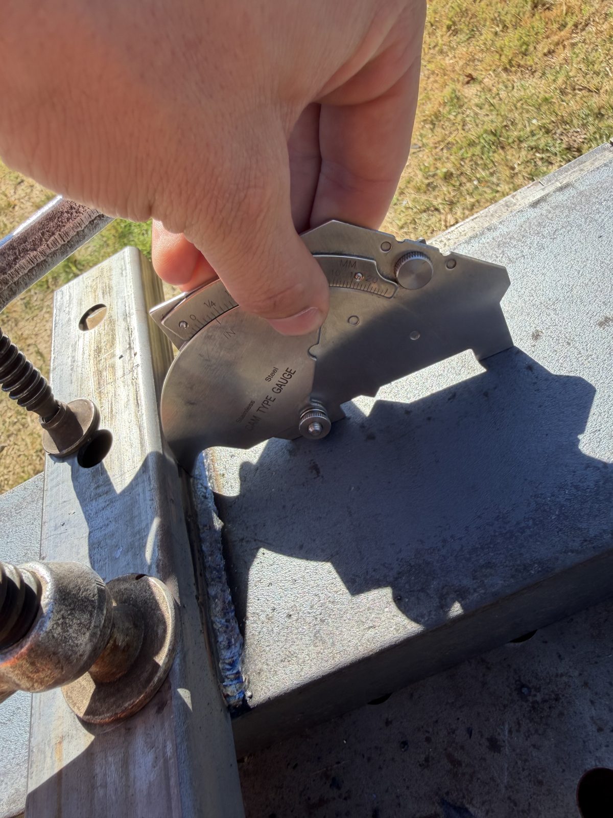 Special inspector checking a CALFAB fillet weld with a cam-type weld gauge